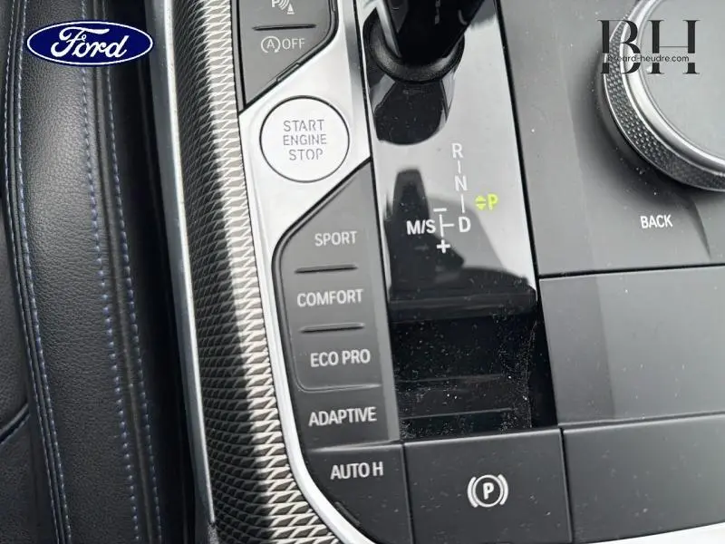 Gros plan sur la console centrale noire de la BMW Série 4 Gran Coupe avec sélecteur de mode de conduite et bouton Start Engine Stop.