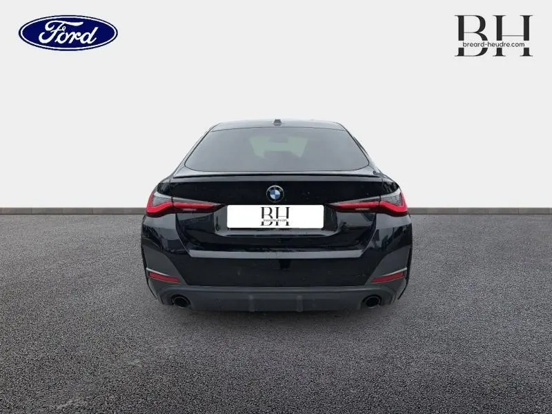 Vue arrière d'une BMW Série 4 Gran Coupe F36 420iA M Sport en noir saphirschwarz métallisé avec feux LED et double sortie d'échappement.