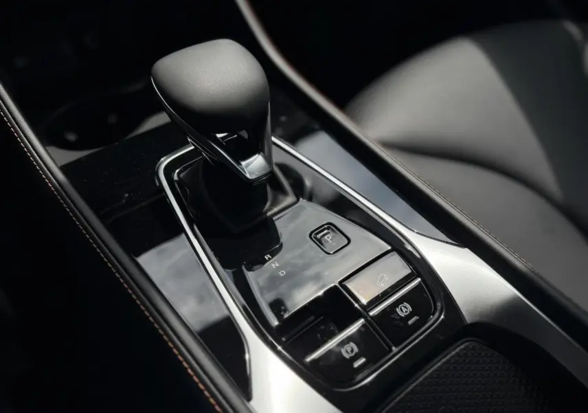 Gros plan sur la console centrale noire du MG Motor EHS 1.5 Hybrid+ 224 Luxury avec levier de vitesse automatique.