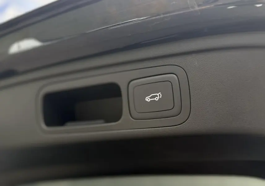 Gros plan sur le bouton d'ouverture électrique du hayon du MG Motor EHS 1.5 Hybrid+ 224 Luxury noir.