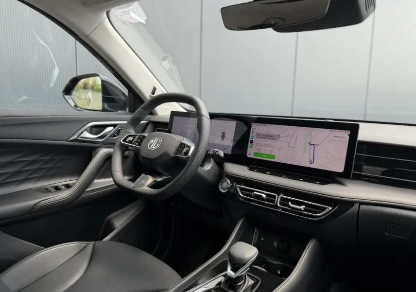Intérieur noir du MG Motor EHS 1.5 Hybrid+ 224 Luxury vu côté conducteur, avec écran tactile large et volant multifonction.