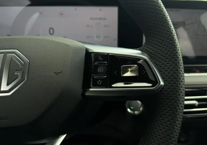 Gros plan sur le côté droit du volant noir perforé du MG MOTOR EHS 1.5 Hybrid+ 224 Luxury avec commandes intégrées.