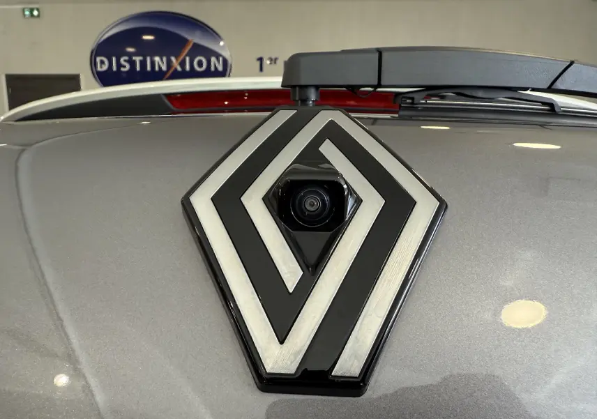 Gros plan sur le logo Renault avec caméra intégrée sur le coffre gris cassiopée métallisé du Captur 2025.