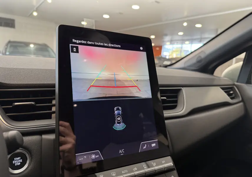 Écran central du tableau de bord du Renault Captur 2025 montrant la caméra de recul avec lignes de guidage colorées.
