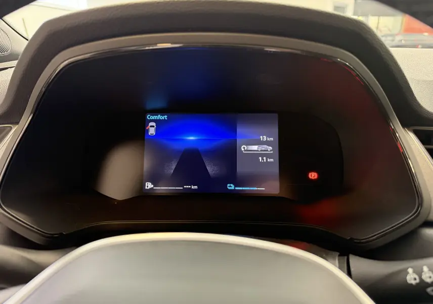 Tableau de bord numérique du Renault Captur 2025 affichant l'autonomie et mode confort, vu de face côté conducteur.