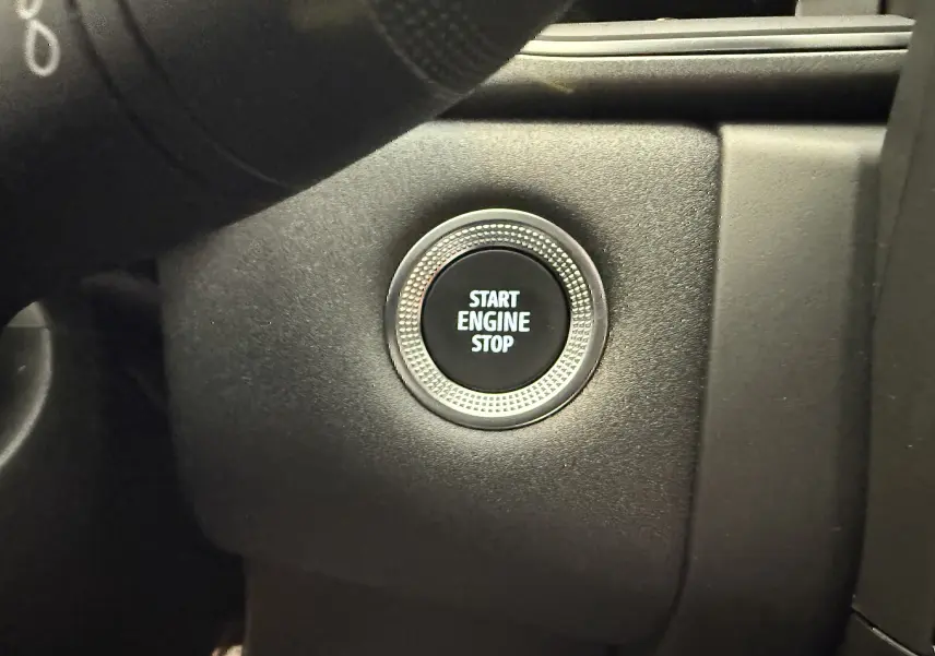 Bouton démarrage moteur rond avec inscription "START ENGINE STOP" sur tableau de bord noir du Renault Captur hybride 2025.