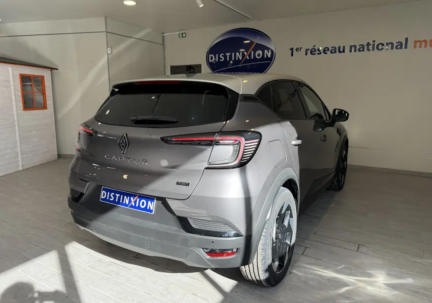 Vue 3/4 arrière droite du Renault Captur 1.6 E-TECH Full Hybrid 145ch en gris Cassiopée métal avec toit gris.