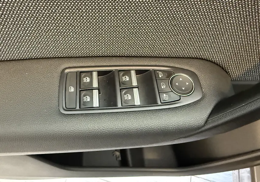 Panneau de commandes des vitres électriques et rétroviseurs sur la portière côté gauche d’un Renault Captur gris Cassiopée 2025.