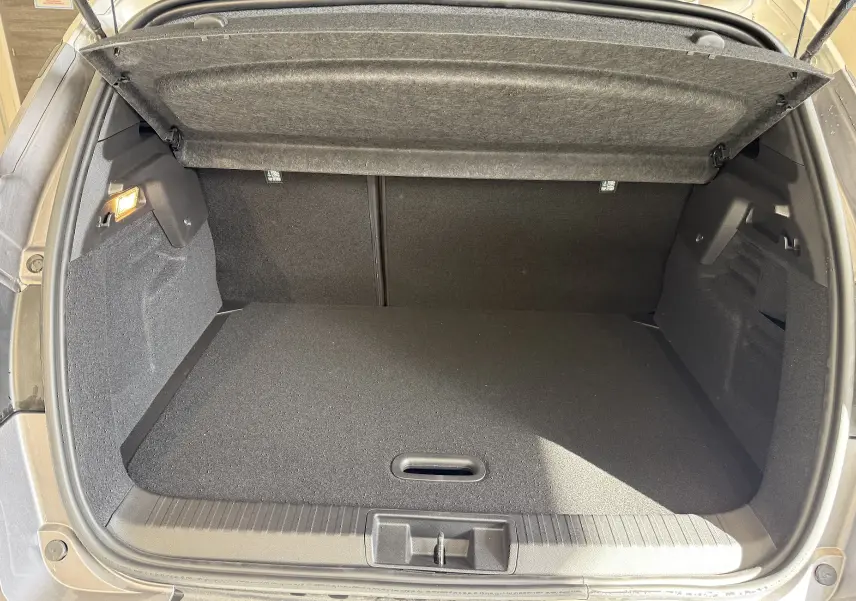 Coffre ouvert du Renault Captur gris Cassiopée métal, vue intérieure montrant l'espace de chargement vide et la moquette noire.