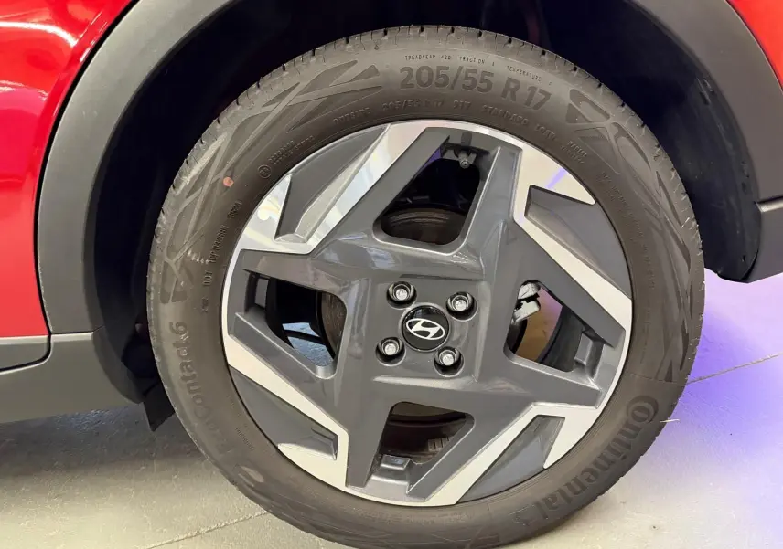Gros plan sur la jante alu 17'' gris foncé avec inserts argentés du côté gauche d'une Hyundai Bayon rouge.
