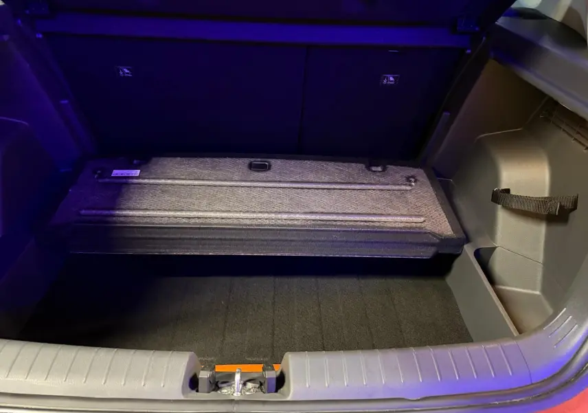 Coffre ouvert du Hyundai Bayon rouge 2025 montrant le compartiment de rangement sous plancher.