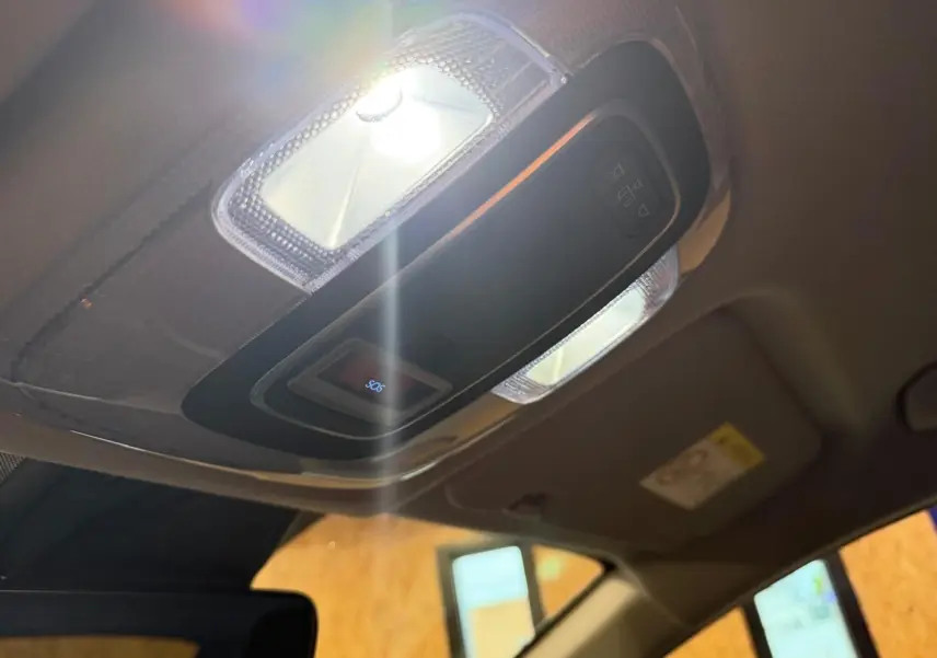 Plafonnier intérieur allumé avec bouton SOS visible dans l'habitacle du Hyundai Bayon rouge 2025.