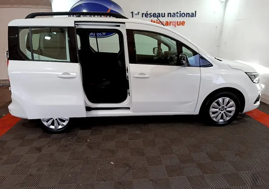 Renault Kangoo blanc vue de profil droit avec porte coulissante arrière ouverte en intérieur showroom.