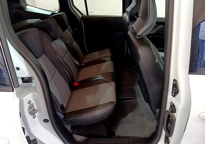 Vue intérieure côté gauche montrant la banquette arrière en tissu gris et noir du Renault Kangoo blanc 2022.