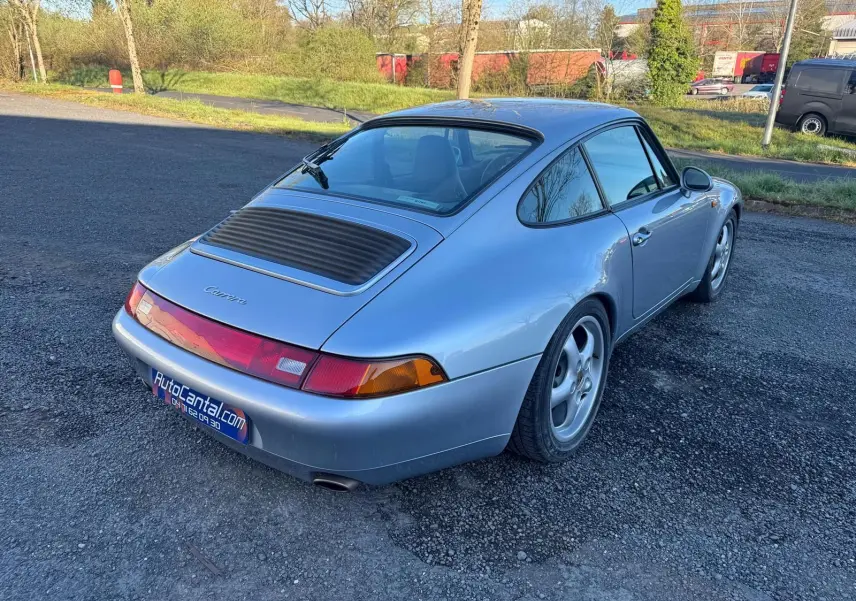 Vue 3/4 arrière droite d'une Porsche 911 Carrera 993 gris polaire avec jantes 17 pouces et pare-brise teinté dégradé.
