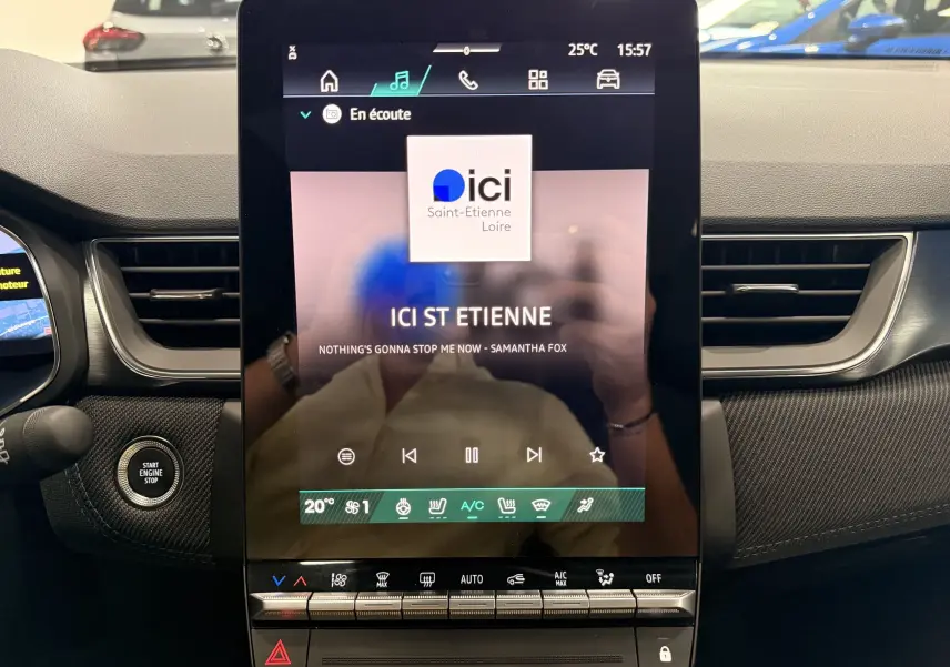 Vue intérieure centrée sur l’écran tactile vertical du Renault Symbioz gris Rafale, avec commandes climatisation et bouton start visible.