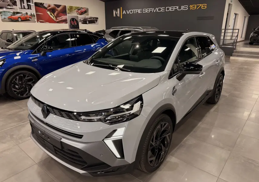 Renault SYMBIOZ gris Rafale en 3/4 avant droit, avec jantes noires et éclairage LED distinctif en showroom.