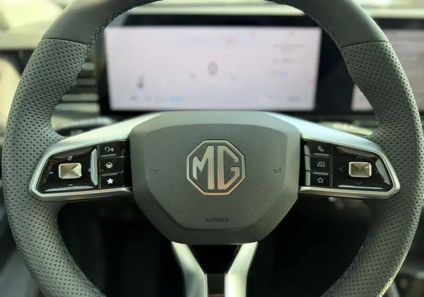Volant noir perforé du MG Motor EHS 1.5 Hybrid+ 224 Luxury avec logo MG central et commandes intégrées.