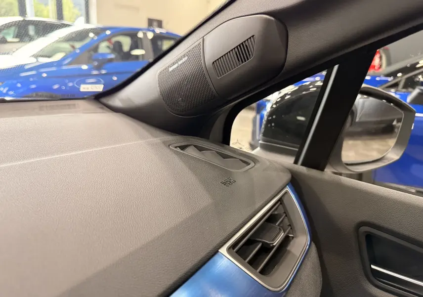Vue intérieure côté droit du tableau de bord gris avec haut-parleur Harman Kardon et rétroviseur du Renault Symbioz Gris Rafale.