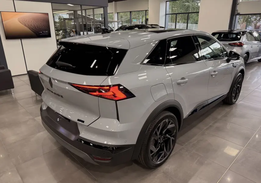 Vue 3/4 arrière droite du Renault SYMBIOZ gris Rafale en showroom, avec jantes noires et vitres teintées.