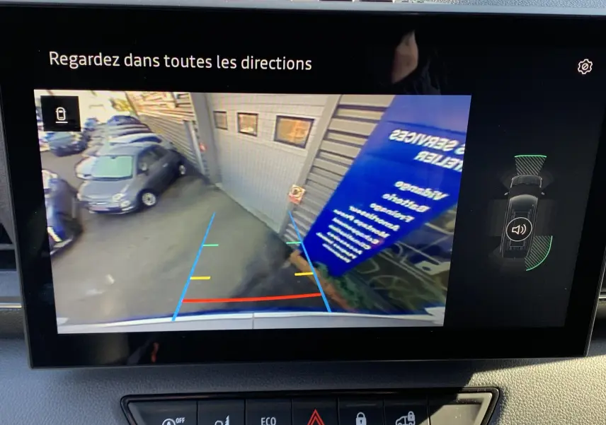 Vue de l'écran de recul du Renault Master blanc, affichant les lignes d'aide au stationnement et l'environnement arrière du véhicule.