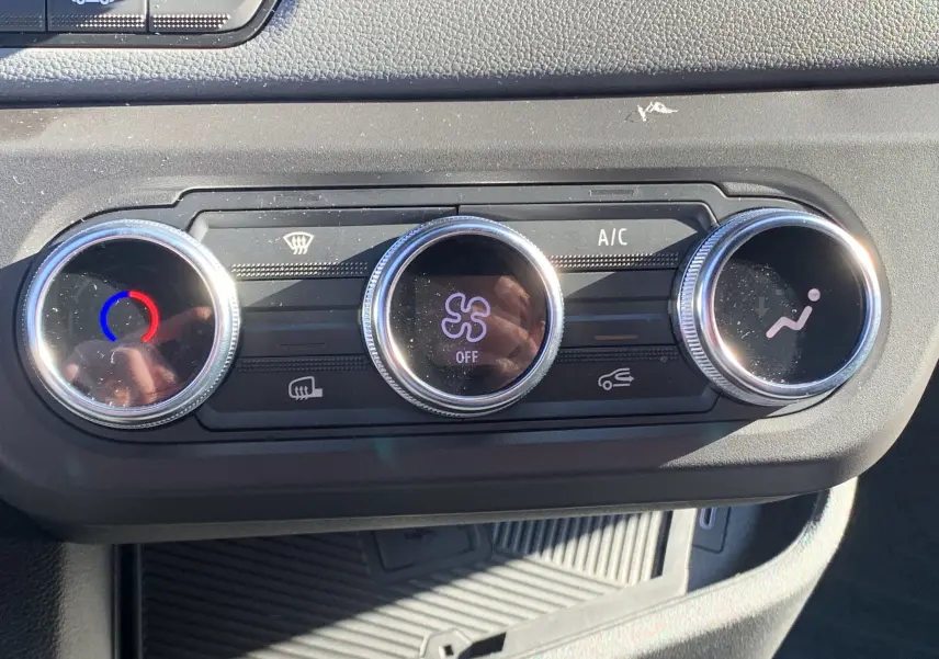 Gros plan sur les commandes de climatisation du Renault Master 2025 blanc, avec réglages circulaires et affichage digital central.