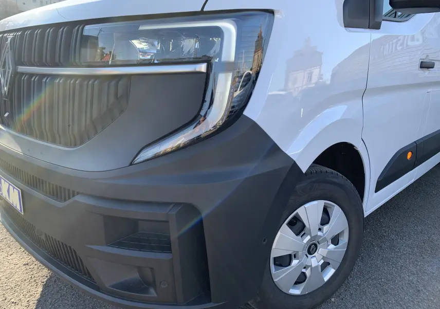 Vue 3/4 avant droit d'un Renault Master blanc mine avec pare-chocs noir mat et jante argentée.