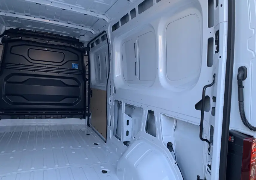 Intérieur du Renault Master blanc mine vu de l'arrière, montrant la cabine de chargement spacieuse et vide.
