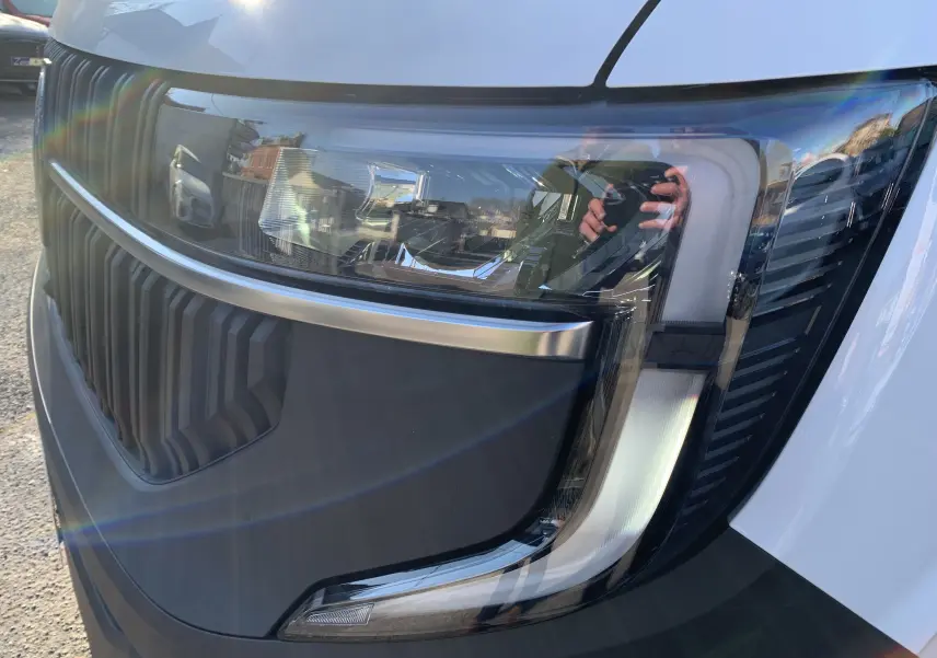Gros plan sur le phare avant droit blanc mine du Renault Master 2025 avec calandre noire et détails chromés.