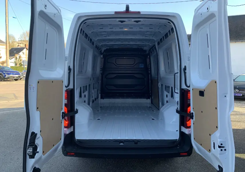 Vue arrière du Renault Master blanc mine 2025 avec portes ouvertes montrant la grande zone de chargement vide et protégée.