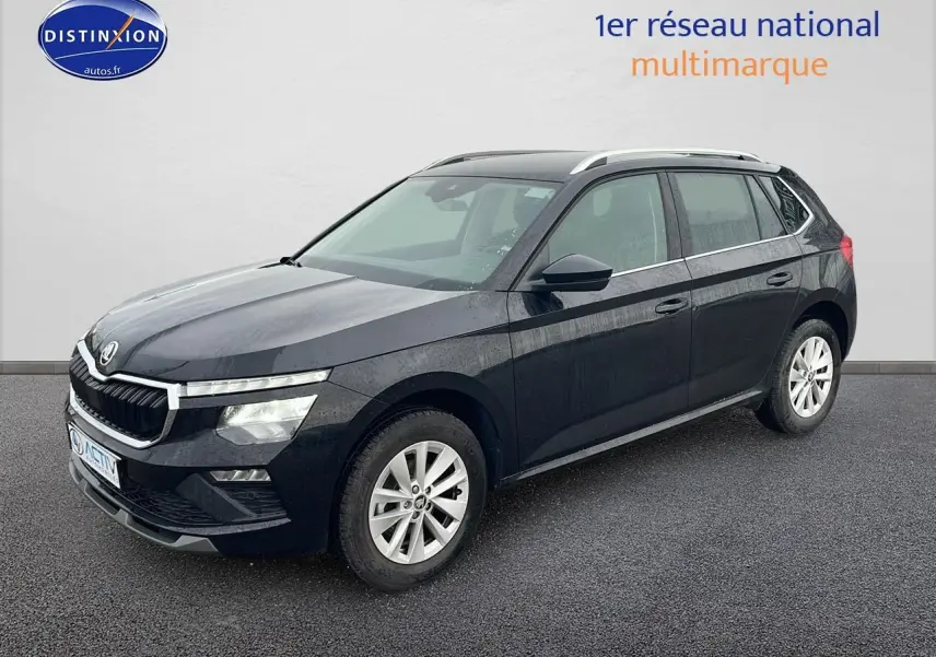 Vue 3/4 avant d'un Skoda Kamiq noir 2025 avec calandre chromée et jantes alu sur sol gris.