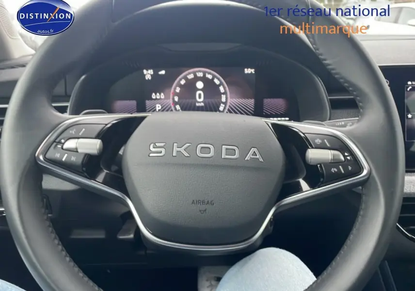 Vue rapprochée du volant cuir multifonction SKODA noir avec logo central et commandes intégrées.