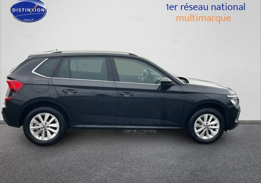 Vue de profil côté gauche d'un Skoda Kamiq noir 2025 avec jantes alu et barres de toit chromées.