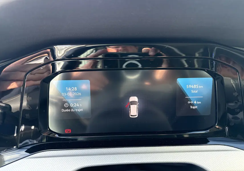 Affichage numérique du tableau de bord d'une Volkswagen Golf blanche 1.0 TSI 110 LIFE, montrant la durée et distance du trajet.