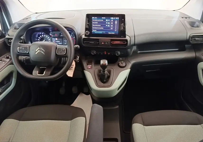 Vue intérieure frontale du tableau de bord du Citroën Berlingo blanc avec écran tactile et volant multifonctions.