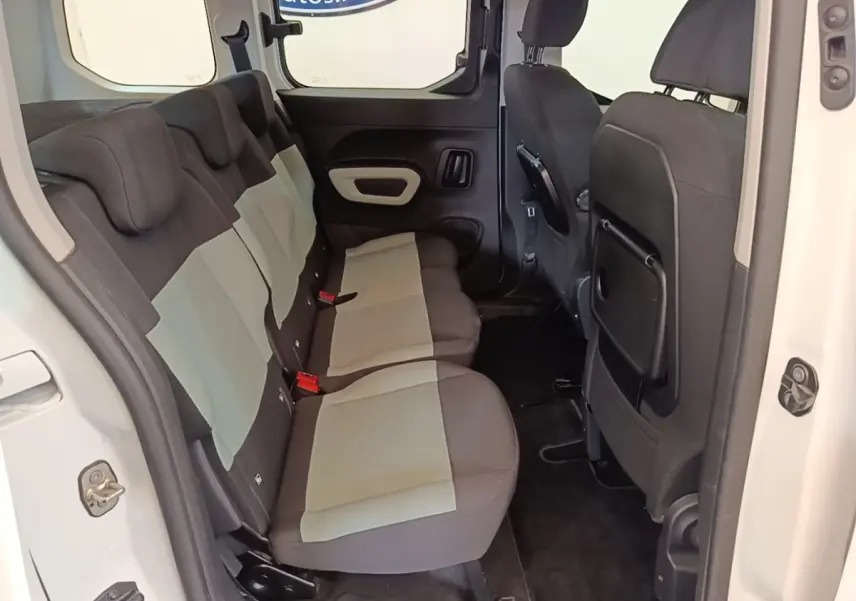 Vue intérieure côté gauche sur la banquette arrière bicolore grise et noire du Citroën Berlingo blanc 2022.