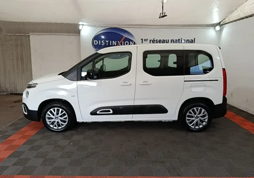 Vue de profil côté gauche d'un Citroën Berlingo blanc 2022 avec protections latérales noires et jantes alliage.