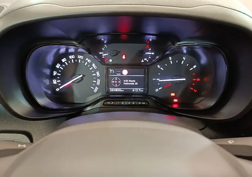 Vue rapprochée du tableau de bord noir du Citroën Berlingo 2022 avec affichage numérique et compteurs analogiques.