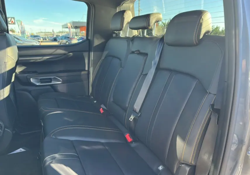Vue latérale droite de la banquette arrière en cuir noir avec surpiqûres jaunes du Ford Ranger Wildtrak 2025 gris carbone.