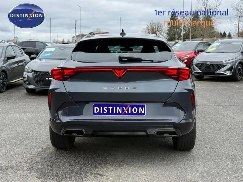 Vue arrière d'une CUPRA Formentor 1.5 eTSI Hybrid 2025 en gris magnétique mat avec feux arrière étirés et double sortie d'échappement.