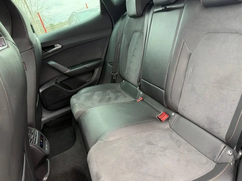 Vue intérieure arrière côté droit de la CUPRA Formentor 1.5 eTSI Hybrid 2025 avec sièges en cuir et alcantara gris.