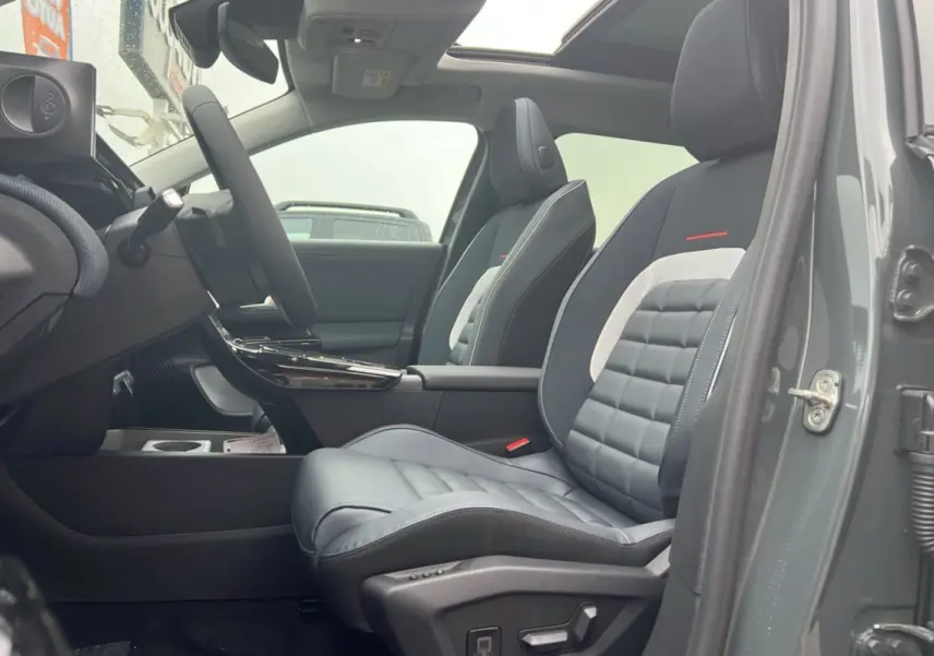 Vue intérieure côté conducteur du Citroën C5 Aircross vert astoria, sièges avant cuir et tissu gris avec accoudoir central.