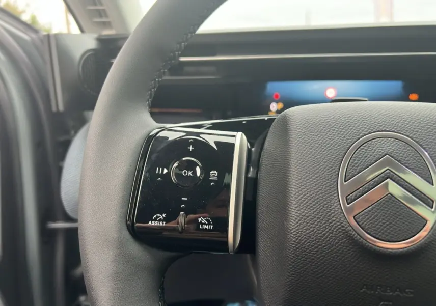 Gros plan sur le volant cuir multifonctions Citroën C5 Aircross New Hybrid 145, avec logo chromé au centre.
