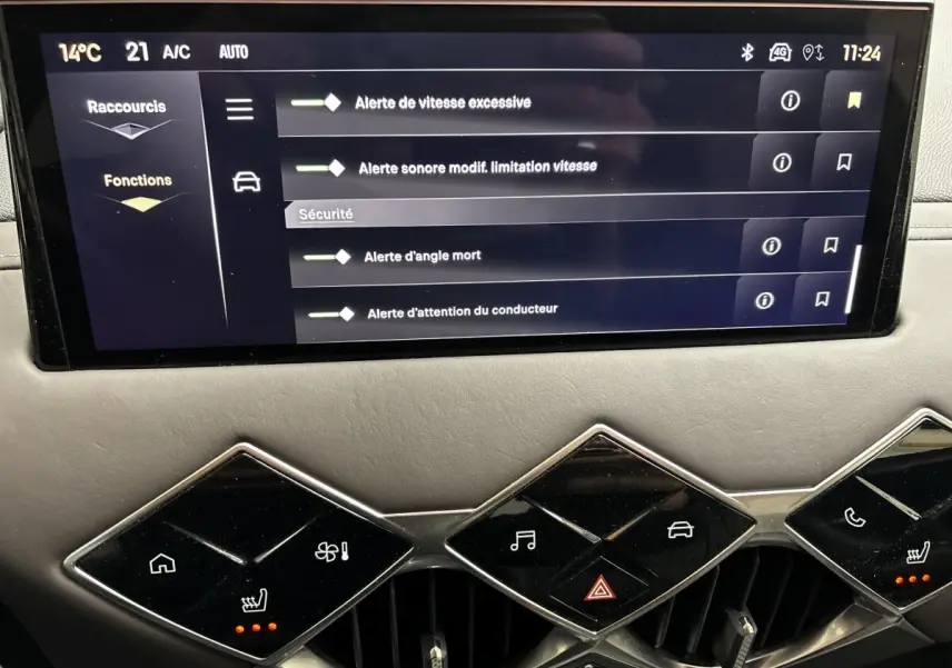 Écran tactile central du tableau de bord du DS3 2024 gris foncé, avec commandes climatisation et alertes sécurité affichées.