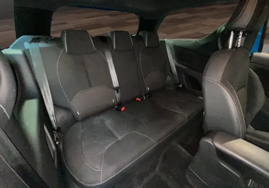 Vue intérieure sur la banquette arrière noire de la Citroën DS3 e-HDi 90 Airdream So Chic bleu, sièges tissu avec ceintures visibles.