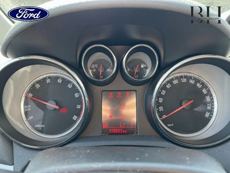 Tableau de bord de l'Opel Mokka gris Minéral, affichage digital rouge et compteurs ronds analogiques vus de face.