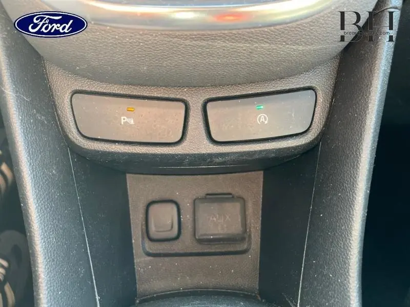 Gros plan sur les commandes du frein de parking et arrêt auto du moteur dans l'habitacle d'un Opel Mokka gris minéral.