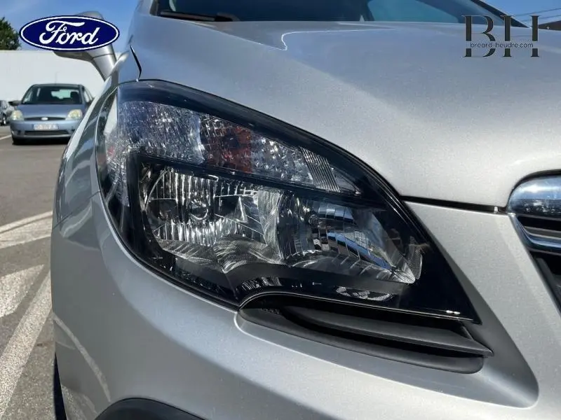 Gros plan sur le phare avant droit d'un Opel Mokka gris minéral, avec calandre partiellement visible.