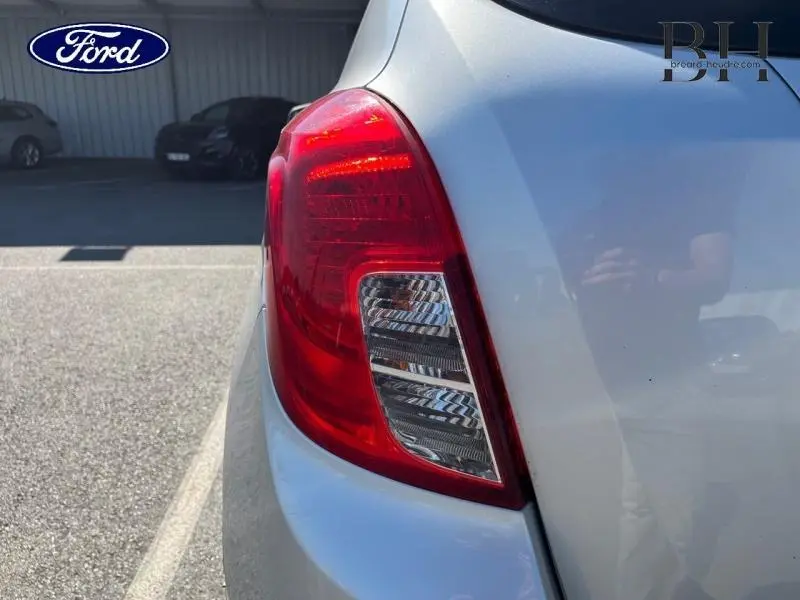 Gros plan sur le feu arrière droit d'une Opel Mokka gris minéral, avec reflet sur la carrosserie claire.