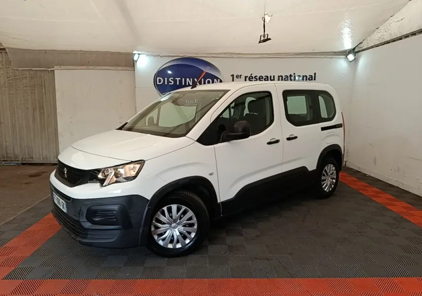 Peugeot Rifter blanc en 3/4 avant droit, avec protections noires sur les bas de caisse et jantes argentées.
